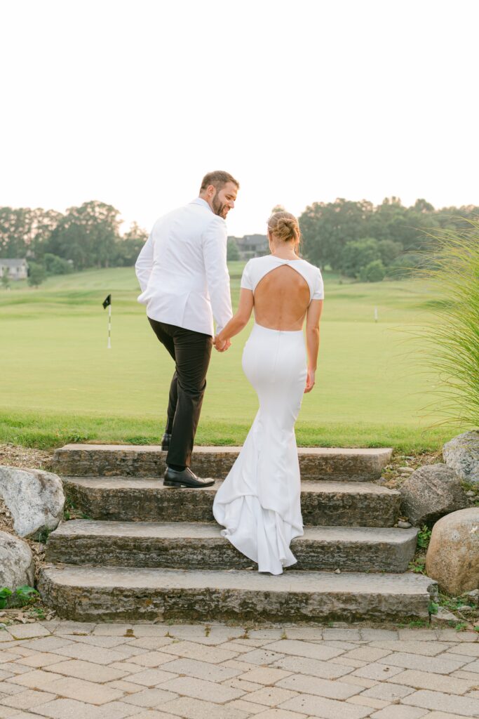 Image of a couple on their wedding day walking onto the golf course